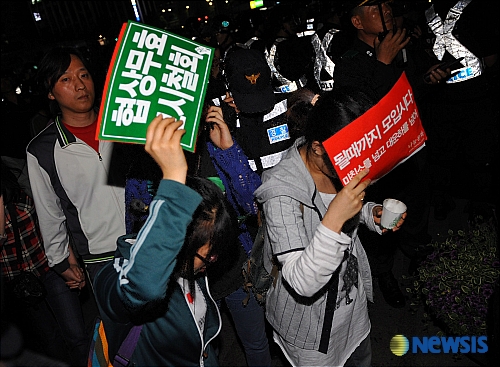 ↑27일밤 미국산쇠고기 수입반대 촛불집회에 참여한 일부 시민들이 가두시위 중 서울광장에서 경찰에 연행되고 있다.   <br>
