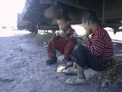 ↑2006년 함경북도의 한 도시에서 꽃제비 아이들이 구걸한 빵을 기차길 부근에서 먹고 있다. ⓒ좋은벗들