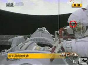 ↑ 기포로 의심되는 작은 물체가 우주인의 헬멧에 달라붙었다 날아가고 있다(CCTV 캡처)