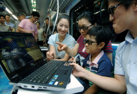 ↑LG전자가 9일부터 15일까지 서울 2호선 지하철에서 3D를 즐길 수 있는 이색공간인 ‘엑스노트 3D 트레인’을 운영한다. 엑스노트 3D 노트북과 엔씨소프트의 인기게임‘아이온(AION)’이미지의 랩핑 광고가 적용된 2호선 전철 차량 내 승객들이 LG전자 엑스노트 3D 노트북을 통해 실감나는 3D 영상을 체험하고 있는 모습.  <br>
