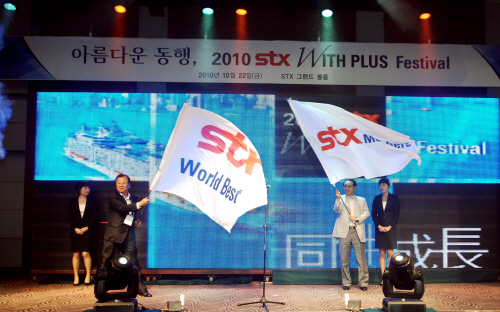 강덕수 STX그룹 회장(사진 오른쪽)과 김승재 STX멤버스 회장(주식회사 한조 사장, 왼쪽)이 각각 ‘STX Members’와 ‘STX World Best’가 새겨진 깃발을 흔들고 있다.