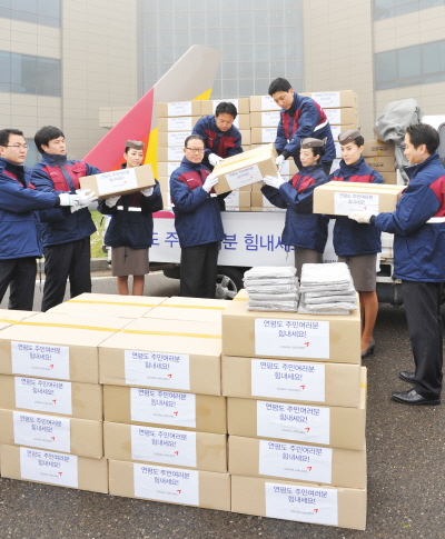 ↑29일 서울 오쇠동 아시아나항공 본사에서 아시아나항공 윤영두 사장(왼쪽 4번째)과 임직원들이 연평도 주민들에게 전달할 기내담요 2000장을 트럭에 싣고 있다.
