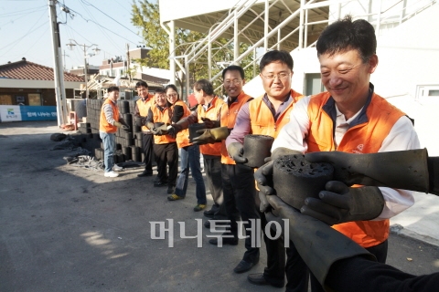 ↑ 한화건설 직원들이 '사랑의 연탄나르기' 봉사활동에 참여하고 있다. 