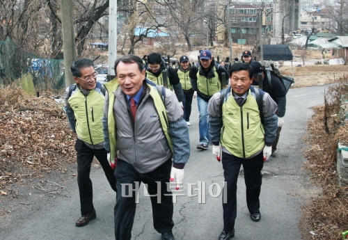 ↑박상진 대표이사(앞줄 가운데) 등 한양 임직원 50여명이 지난 23일 인천에서 연탄지게를 매고 '사랑의 연탄나르기'를 진행하고 있다.