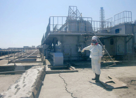 ↑ 방사능 오염수가 발견된 2호기 배수구 인근의 전기케이블 보관시설(작업원이 손가락으로 가리키고 있다). ⓒ도쿄전력 제공