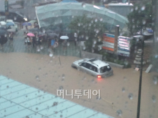 ↑27일 오전 서울 강남역 4번 출구쪽 이면도로가 침수되면서 이동하던 차량이 물에 빠져 헤어나오지 못하고 있다.
