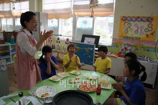 ↑한국외식산업연구소의 강버들 연구원(맨 왼쪽)은 칠보초 아이들에게 주먹밥 만드는 법을 가르쳤다. ⓒ하하야