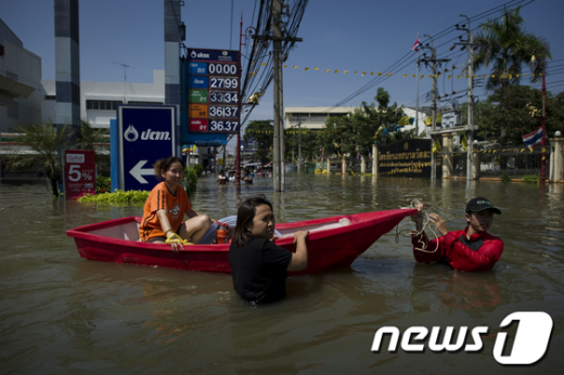 19일(현지시간) 태국 수도 방콕 부근 논타부리 주민들이 홍수로 불어난 물때문에 보트를 타고 탈출하고 있다. 