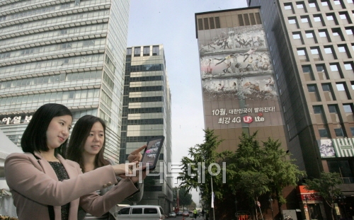 ↑LG유플러스가 전국에 위치한 LG유플러스의 사옥을 비롯, 서울 중심지의 대규모 건물에 U+ LTE의 대대적인 옥외 광고를 하고 있다. 사진은 청계광장에 설치된 옥외광고. 