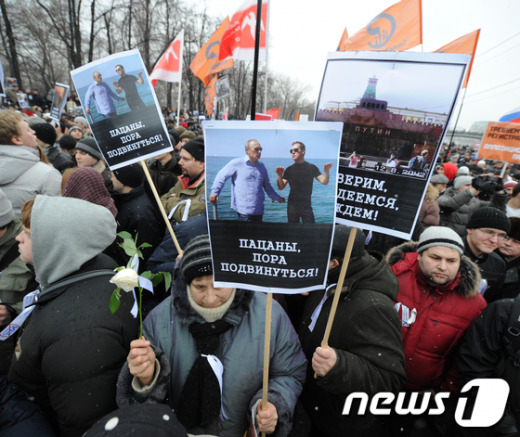 10일 러시아 모스크바에서 부정선거 규탄 시위자들이 "소년이여, 이제 그만 돌아갈 시간이야"(왼쪽)와 "우리는 희망과 기대가 있다고 믿는다!"는 피켓을 들고 시위하고 있다. AFP=News1