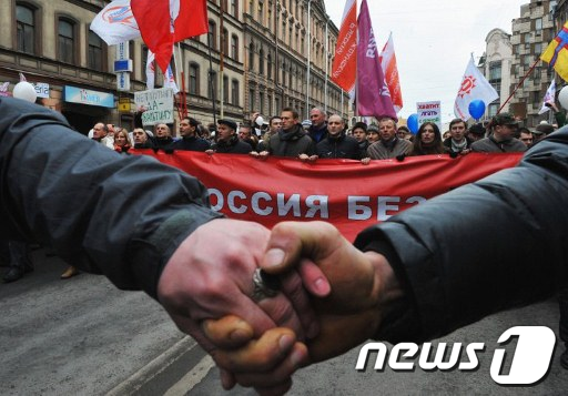 러시아의 민주화 활동가 알렉세이 나발니가 이끄는 반(反)푸틴 시위가 25일(현지시간) 수천명이 참여한 가운데러시아 상페테르부르크에서 열렸다. 이들은 손에 손잡고 푸틴의 대선 출마를 비판했다. AFP=News1
