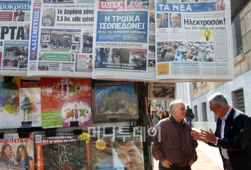 ↑ 아테네 시민들이 신문 가판다 옆에서 얘기를 나누고 있다. 가판대 신문엔 전날 벌어진 긴축 반대 시위의 모습을 담은 사진일 실려 있다. ⓒ사진=아테네 홍봉진 기자