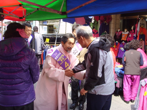 ↑경남 사천·남해·하동 통합진보당 강기갑 후보가 4일 삼천포 5일장에서 주민들과 만나고 있다.