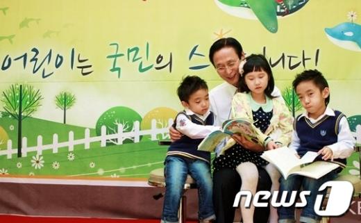 민병덕 국민은행장이 아이들과 책을 보고 있다. News1
