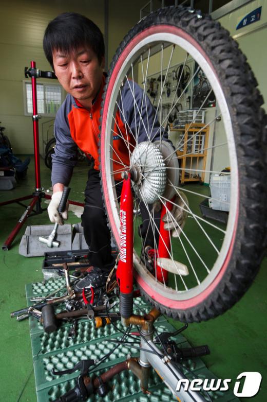 [사진]폐자전거 수리하는 직원