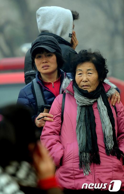 지난 1월 27일 오후 서울 강남구 개포동 구룡마을 판자촌에서 불이 난 가운데 주민들이 소방대원들의 화재진압을 보며 망연자실한 표정을 짓고 있다. News1 이명근 기자
