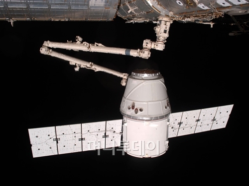 지난 5월 국제우주정거장의 로봇 팔이 우주선 '드래곤'을 움직이고 있는 모습. 