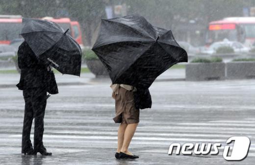 제16호 태풍 산바(SANBA)가 대구에 상륙해 내륙을 관통하고 있는 17일 오후 강풍과 함께 폭우가 쏟아지는 서울 세종로사거리에서 우산을 쓴 시민들이 발걸음을 재촉하고 있다.  News1 박세연 기자