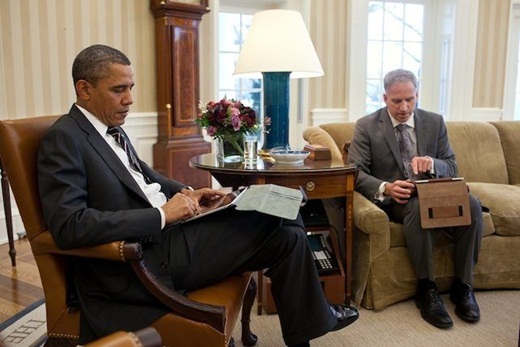 버락 오바마 미국 대통령이 2012년 1월 31일 백악관 대통령 집무실에서 아이패드를 손에 든 채 로버트 카틸로 국가정보국장의 일일 브리핑을 듣고 있다.