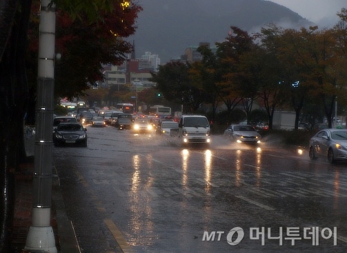 ↑27일 부산시내 모습. 폭우로 자동차들이 물길을 가르며 운행하고 있다.ⓒ송학주