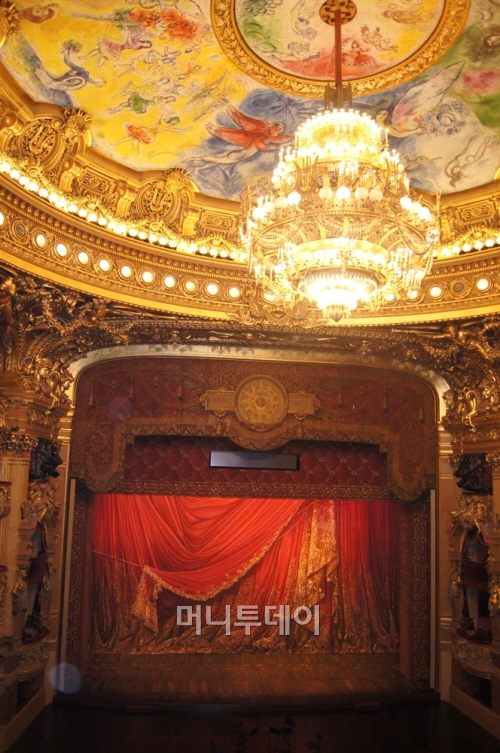 ↑무대위 천장을 장식하고 있는 마르크 샤갈의 환상적인 천장화 .  화려한 샹들리에 아래 450명의 배우가 동시에 오를 수 있는 웅장한 무대가 자리하고 있다. ⓒ파리=송원진