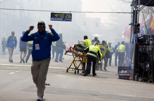 15일(현지시간) 미국 보스턴 마라톤대회 결승점 지점 부근에서 2건의 폭발사고가 발생해 사상자가 속출했다. 아수라장이 된 현장에서 응급 구조 대원들이 환자를 이송하고 있다.(ⓒ블룸버그)