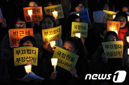지난 19일 서울 태평로 파이낸스빌딩 앞에서 열린 "국정원 국내정치개입 규탄 및 진상규명 촉구대회"에서 참석자들이 촛불을 들고 있다.                                                                                                           2013.4.19/뉴스1  News1 박세연 기자