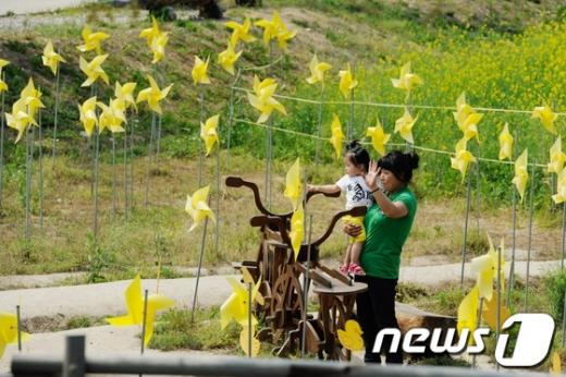 故 노무현 전 대통령 4주기를 하루 앞둔 22일 오후 김해 봉하마을에 설치된 노란 바람개비 앞에서 시민들이 사진을 찍고 있다. 2013.5.22/뉴스1  News1 전혜원 기자