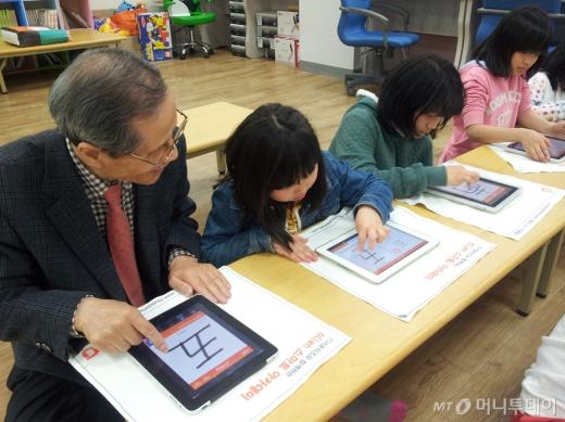 <br>
KT는 2010년 3월부터 누구나 쉽게 스마트기기를 사용할 수 있도록 '올레 스마트 아카데미'를 운영하고 있다. 할아버지와 아이들이 태블릿PC에 한자를 적고 있다./KT 제공 <br>
