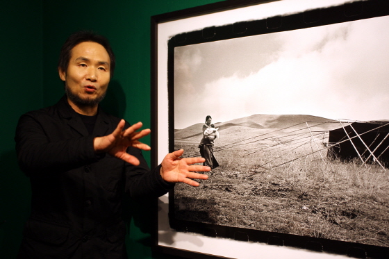 박노해 시인이 자신의 사진 작품 '남김없이 피고 지고' 앞에서 사진에 담긴 사연을 이야기하고 있다. /사진=이언주 기자
