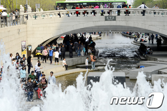 서울 낮 기온이 24.3도까지 오르며 올해 최고 기온을 기록한 13일 오후 서울 청계천에서 시민들이 휴식을 취하고 있다./뉴스1 © News1   안은나 기자