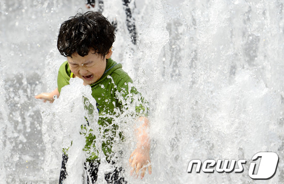 서울 낮 기온이 24.3도까지 오르며 올해 최고 기온을 기록한 13일 오후 서울 광화문 광장 분수에서 어린이들이 물놀이를 하며 더위를 쫓아내고 있다. 2014.4.13/뉴스1 © News1   안은나 기자