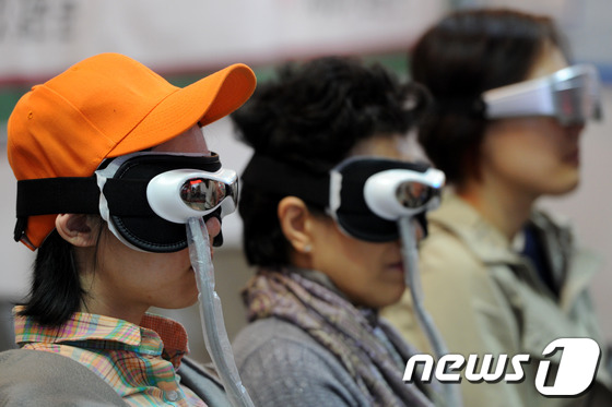 서울 강남구 코엑스에서 열린 2013 국제미용성형엑스포에서 관람객들이 안구건조증 치료기기를 체험하고 있다. /뉴스1 © News1 안은나 기자
