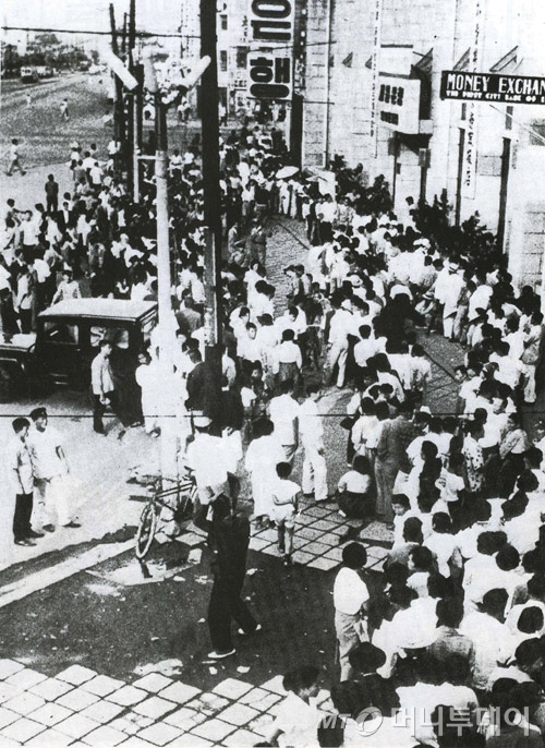 1962년 6월10일을 기해 10환을 1원으로 하는 통화개혁 조치가 발표되자 새로운 화폐로 환전하기 위해 은행 앞에 길게 줄지어 서 있는 시민들. /사진 제공〓금융투자협회