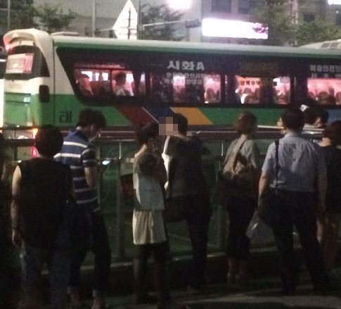지난 18일 서울 강남역 인근에서 버스를 기다리던 한 시민이 역 구조물에 몸을 기댄 채 버스가 오는 곳을 물끄러미 바라보고 있다./ 사진=김종훈 기자