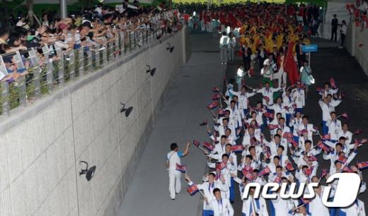 [사진]손 흔들며 경기장 들어서는 북한 선수단