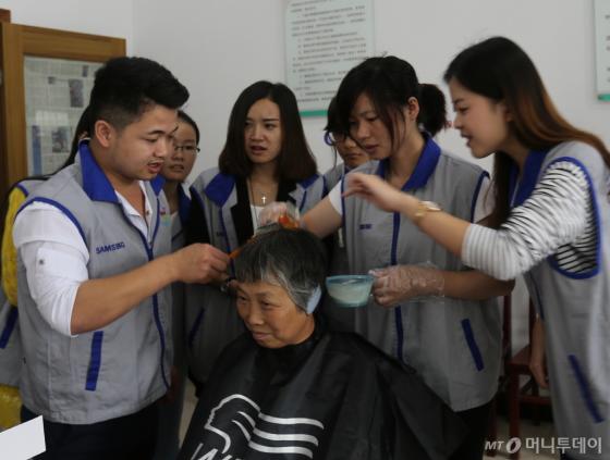 중국삼성이 최근 쑤저우에서 개최한 자원봉사 대축제에서 직원들이 봉사활동을 펼치고 있다/사진제공=중국삼성 