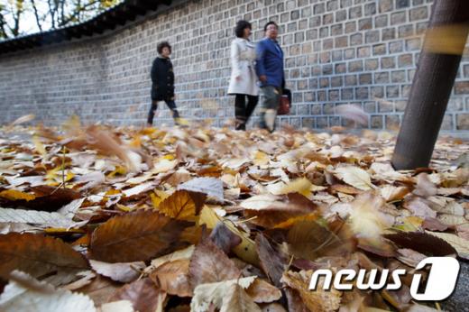 서울 중구 정동길을 찾은 시민들이 옷깃을 여미고 바람에 흩날리는 낙엽을 바라보며 가을의 정취를 즐기고 있다. © News1 유승관 기자