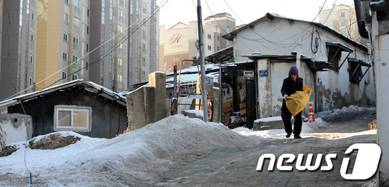 서울 동작구에서 한 남성이 쓰레기 봉투를 들고 눈 내린 길을 걷고 있다./ 사진=뉴스1