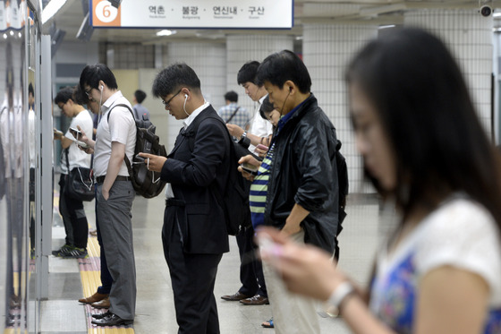 서울 지하철에서 출근 길에 오른 회사원들이 스마트폰을 보고 있다/ 사진=뉴스1