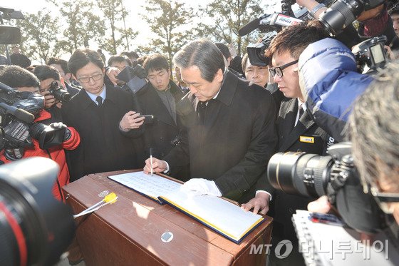  새누리당 김무성 대표가 14일 오전 경남 김해 봉하마을 노무현 대통령 묘역을 찾아 참배한 뒤 방명록을 쓰고 있다. 사진=뉴스1.