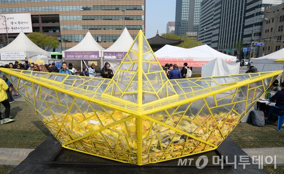  세월호 여객선 침몰 참사 1주기를 하루 앞둔 15일 서울 광화문 광장에 설치된 투명 모형배 안에 시민들의 추모메시지를 품에 안은 노란 종이배가 담겨 있다./ 사진=뉴스1