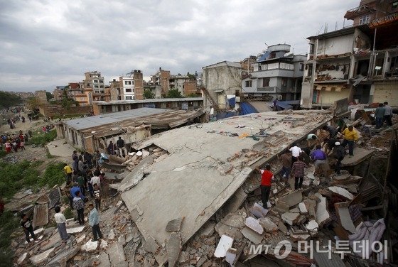  25일 진도 7.9의 강진으로 집이 무너진 네팔 카트만두에서 주민들이 생존자를 찾고 있다.   이번 지진으로 지금까지 천여명이 숨진것으로 알려지고 있다. 현지인들은 건물에 매몰된 사람들이 많아 사망자가 눈덩이처럼 불어날 것으로 우려하고 있다. 2015.4.26 로이터/사진=뉴스1