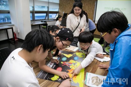 소셜벤처 세상을품는아이의 나눔액션 수업 중 아이들이 비누가 굳는 동안 빈곤지도 퍼즐을 맞추고 있다./사진제공=이우기 작가, 서울시 사회적경제지원센터