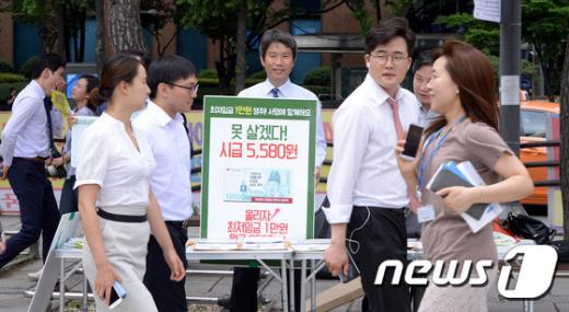 새정치민주연합 이인영 의원이 지난 19일 오후 서울 종로구 보신각 앞에서 최저임금 1만원 인상을 위한 런치문화제를 열고 최저임금 1만원 인상을 위한 서명 캠페인을 하고 있다. © News1 이동원 기자