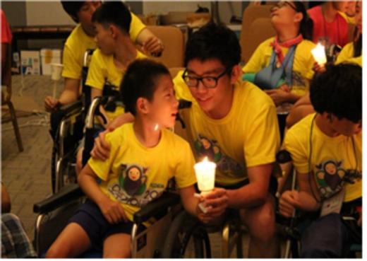 지난해 열린 오뚜기 여름캠프에 참가한 학생이 자원봉사자와 촛불을 맞잡고 있다. (한국뇌성마비복지회 제공) © News1