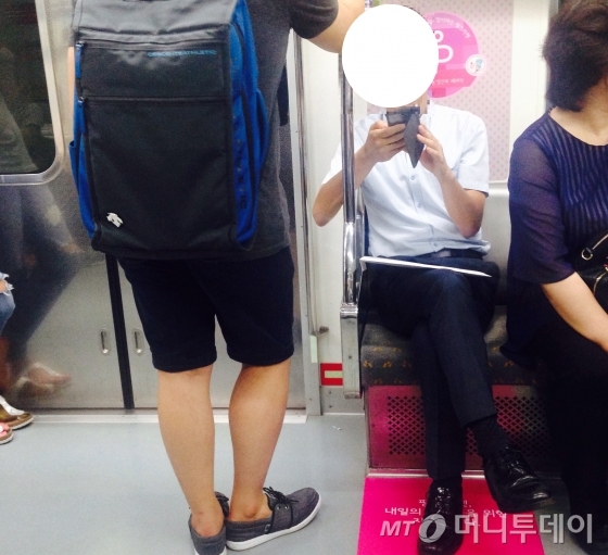 좌석과 벽·바닥까지 핑크색으로 구분한 지하철 임산부석에 한 30대 남성이 앉아 스마트폰을 보고 있다./사진=남형도 기자