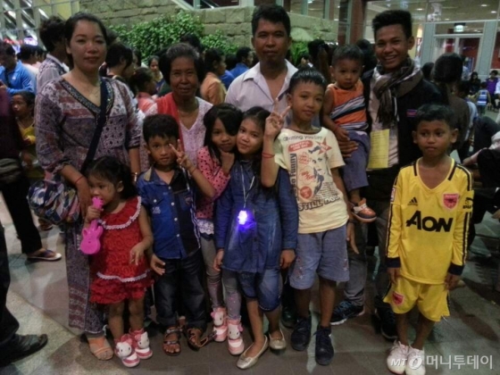 지난 8월30일 캄포디아 프놈펜 공항에서 한국으로 떠나는 근로자 트 찬리씨(23, 윗줄 오른쪽 끝)가 배웅나온 가족들과 함께 기념사진을 찍고 있다. / 사진제공=트 찬리씨