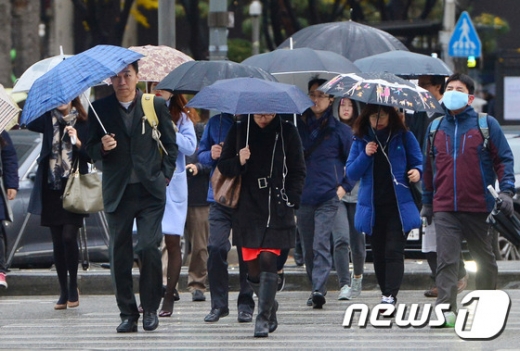 올들어 서울에 첫눈이 공식 관측된 25일 오전 서울 광화문네거리에서 우산을 쓴 시민들이 출근길 발걸음을 재촉하고 있다. 기상청은 이날 서울 아침 기온은 2도, 낮 기온은 4도로 당분간 평년보다 낮을 것으로 내다봤다. 2015.11.25/뉴스1 © News1 구윤성 기자