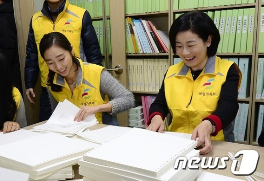 김희정 여성가족부 장관(오른쪽)이 2014년 12월26일 오전 서울 강서 점자도서관을 찾아 여성가족부 직원들과 함께 시간장애인을 위한 봉사활동을 하고 있다. /뉴스1 © News1 박지혜 기자